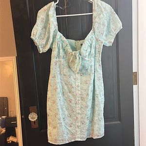 light blue, fitted dress with puff sleeves. Knotted front.